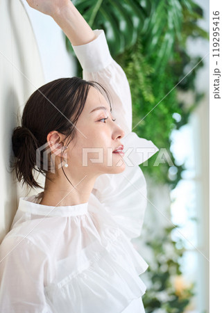 壁にもたれかかる女性 119295416