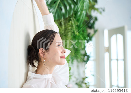 壁にもたれかかる女性 119295418