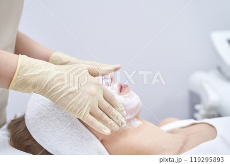 Esthetician applies facial treatment with gloves for relaxation and skincare Esthetician applies facial treatment with gloves for relaxation and skincare 119295893