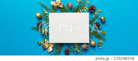 Flat lay Christmas composition. square Paper blank, pine tree branches, christmas decorations on Colored background. Top view, copy space for text 119296556