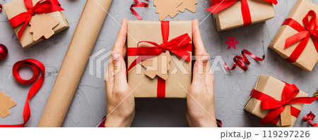 Woman hands holding gift box, preparing surprise for holiday, top view, Christmas and New Year concept Woman hands holding gift box, preparing surprise for holiday, top view, Christmas and New Year concept 119297226