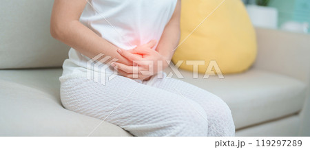 woman having abdomen ache due to Stomach pain, digestion with constipation or Diarrhea from food poisoning, female problem and Endometriosis, Hysterectomy, Stomachache and Menstrual on sofa at home 119297289