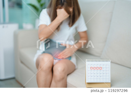 Menstruation period cycle of monthly and Stomachache concepts. woman having abdomen pain with hot water bottle and calendar, illness female suffer from premenstrual ache and body Health problem Menstruation period cycle of monthly and Stomachache concepts. woman having abdomen pain with hot water bottle and calendar, illness female suffer from premenstrual ache and body Health problem 119297296