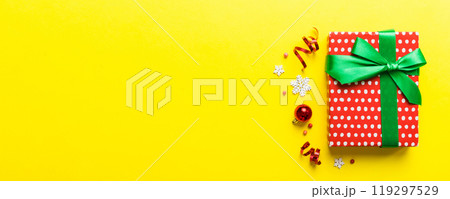 Top view Flat lay Christmas decorations and gift box on colored background with copy space. Christmas or Happy New Year composition 119297529