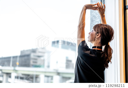 遠くの景色を眺めながら背伸びする女性 遠くの景色を眺めながら背伸びする女性 119298211