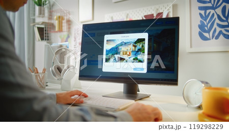 Young man types prompt in AI image generator on PC to generate photo of modern minimalist house 119298229