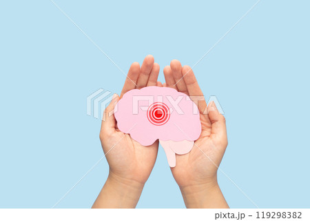 Hands holding brain as pain red circle on light blue background. Concept of headache, stroke disease, migraine, epilepsy, meningitis, brain tumor and dementia. Mental health. Hands holding brain as pain red circle on light blue background. Concept of headache, stroke disease, migraine, epilepsy, meningitis, brain tumor and dementia. Mental health. 119298382