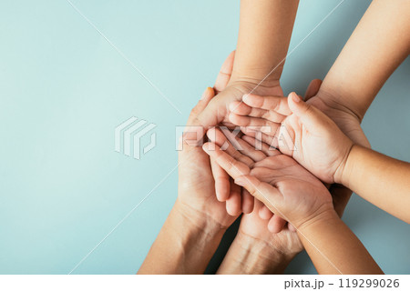 Close-up top view of family hands stacked isolated background. Parents and kid hold empty space expressing support on Family and Parents Day. 119299026