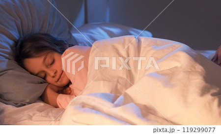 Sleeping child. Night rest. Sweet dreams. Kid bedtime. Cute small girl lying in cozy soft bed tossing turning in dark home bedroom with blue moonlight. Sleeping child. Night rest. Sweet dreams. Kid bedtime. Cute small girl lying in cozy soft bed tossing turning in dark home bedroom with blue moonlight. 119299077