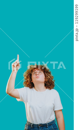 Idea discovery. Surprised curious woman pointing up learning advertising isolated on blue copy space background. 119299199