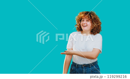 Impressed woman presenting pointing enthusiastically to the side isolated on blue copy space background. 119299216