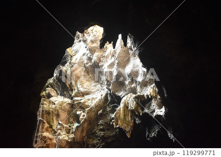 stalagmites and stalactites with sunlight through cave hole in Khao Luang cave travel location on Thailand stalagmites and stalactites with sunlight through cave hole in Khao Luang cave travel location on Thailand 119299771