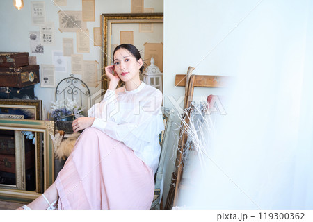 雑貨に囲まれる女性 119300362