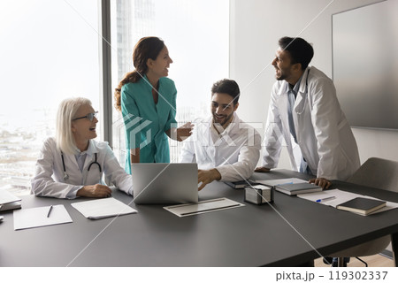 Laughing multiethnic physicians clinic employees having fun on team meeting 119302337