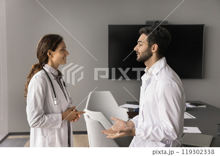Two doctors colleagues hold professional conversation at healthcare center boardroom 119302338