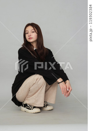 Young girl in a simple sweater, her pensive look capturing the introspective nature and challenges faced by today's youth. 119302384