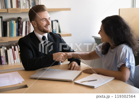 Happy business leader man shaking hands with young professional woman Happy business leader man shaking hands with young professional woman 119302564