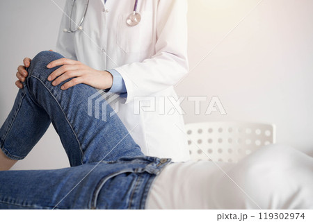 Doctor and patient are at the medical inspection in clinic. Orthopedic examines the knee of a young woman. Medicine concept 119302974
