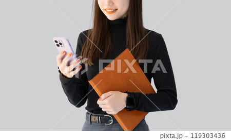 スマホとバインダーを持つ笑顔の女性・ビジネスウーマン 119303436