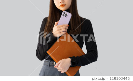 スマホとバインダーを持つ女性・ビジネスウーマン スマホとバインダーを持つ女性・ビジネスウーマン 119303446