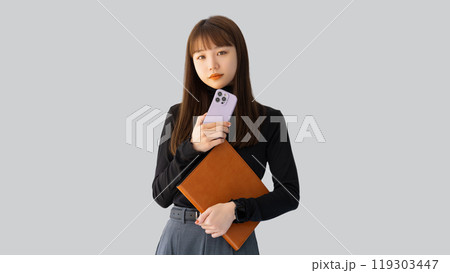 スマホとバインダーを持つ女性・ビジネスウーマン スマホとバインダーを持つ女性・ビジネスウーマン 119303447