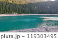 A large body of water that is completely surrounded by trees and rocks 119303495