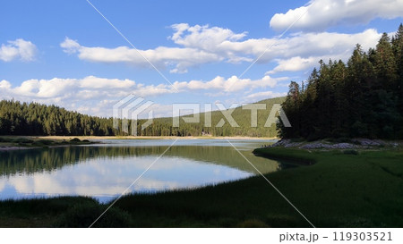 A large body of water that is completely surrounded by trees and rocks A large body of water that is completely surrounded by trees and rocks 119303521