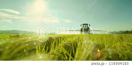 A tractor is spraying fertilizer on a lush green field in the countryside 119304183