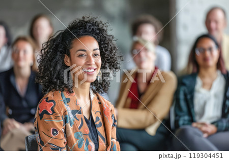 Smiling beautiful black woman attending seminar with audience in background. Trainings, coworking, education 119304451