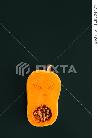 Butternut squash carved with spooky face, showcasing creative Halloween decoration ideas Butternut squash carved with spooky face, showcasing creative Halloween decoration ideas 119304477
