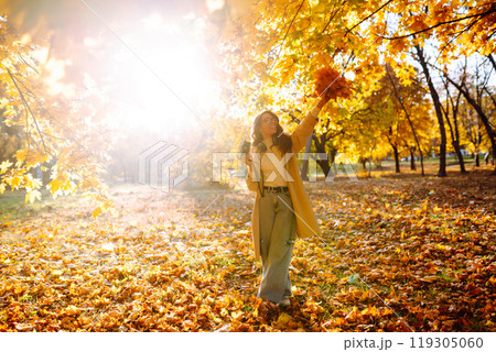 Young woman taking pictures in the autumn forest. Lady Walking In Fall Park With Yellow Foliage. Young woman taking pictures in the autumn forest. Lady Walking In Fall Park With Yellow Foliage. 119305060