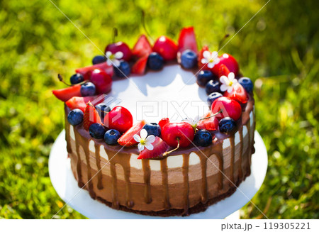 Delicious homemade Three chocolate mousse cake decorated with fresh berries 119305221