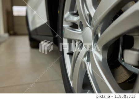 Detailed shot of a sleek black and silver alloy wheel on a motor vehicle Detailed shot of a sleek black and silver alloy wheel on a motor vehicle 119305313