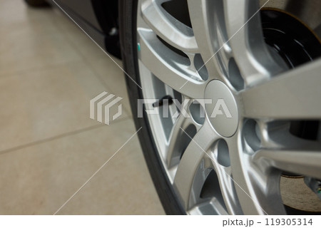 Detailed shot of a sleek black and silver alloy wheel on a motor vehicle Detailed shot of a sleek black and silver alloy wheel on a motor vehicle 119305314