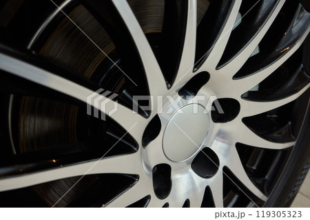 Detailed shot of a sleek black and silver alloy wheel on a motor vehicle 119305323