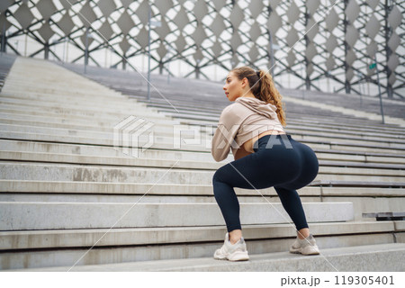 Sports woman in sportswear does exercises outdoors. . Sport, active lifestyle, healthy lifestyle concept. Sports woman in sportswear does exercises outdoors. . Sport, active lifestyle, healthy lifestyle concept. 119305401