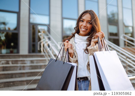 Young woman with shopping bags. Consumerism, purchases, shopping, lifestyle, sale concept. 119305862