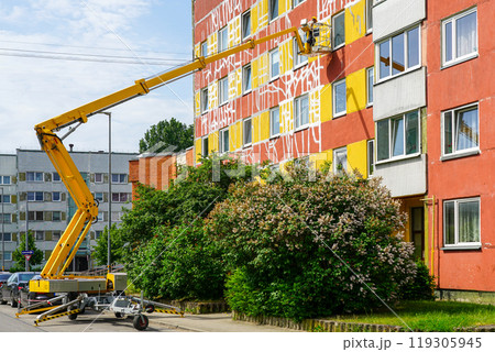 Apartment house facade maintenance works using self propelled telescopic boom lift with basket Apartment house facade maintenance works using self propelled telescopic boom lift with basket 119305945