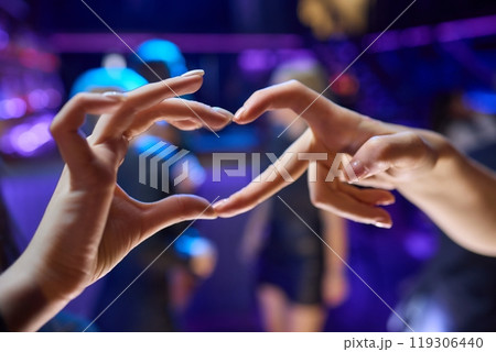 Hands Forming a Heart Shape in the Midst of a Vibrant and Joyful Celebration Event 119306440