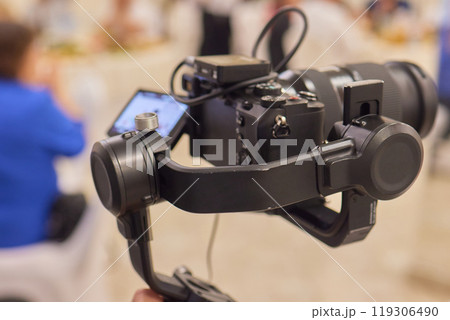 A Professional Camera Stabilizer utilized at a thriving Event setting for capturing stunning visuals A Professional Camera Stabilizer utilized at a thriving Event setting for capturing stunning visuals 119306490