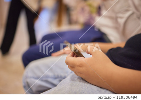 In the waiting area, children are actively engaging with various technology devices In the waiting area, children are actively engaging with various technology devices 119306494