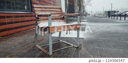 A snow-covered bench sits alone on a city...の写真素材 [119306547] - PIXTA