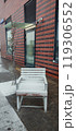 Snow-covered chair outside a modern building on a chilly winter day in an urban setting 119306552