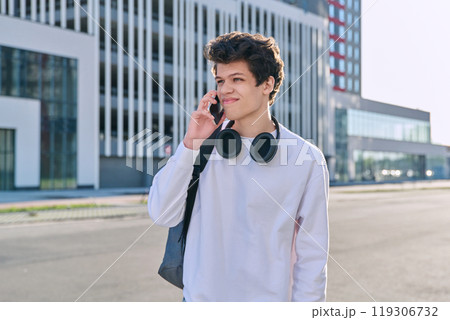 Young serious guy talking on mobile phone, modern city background, urban style Young serious guy talking on mobile phone, modern city background, urban style 119306732