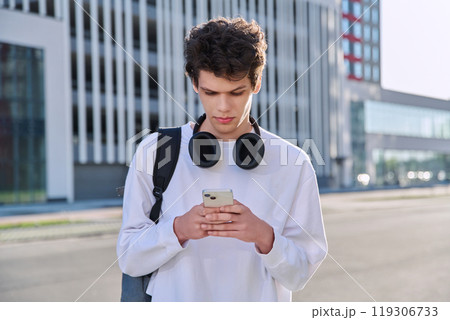 Handsome young male using smartphone, urban outdoor Handsome young male using smartphone, urban outdoor 119306733