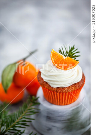 Homemade delicious tangerine and carrot cupcakes, decorated with creamcheese and fresh citrus fruits Homemade delicious tangerine and carrot cupcakes, decorated with creamcheese and fresh citrus fruits 119307028