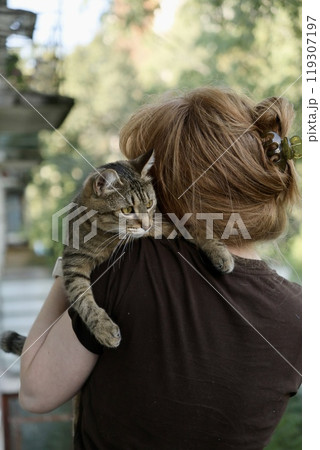 woman and cat. happy European woman lovingly hugs her cute tabby cat at home, woman and cat. happy European woman lovingly hugs her cute tabby cat at home, 119307197