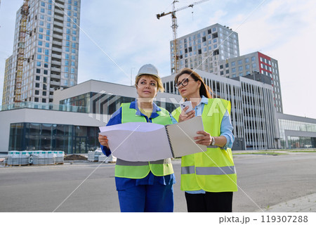 Two confident women talking working on construction of residential office building Two confident women talking working on construction of residential office building 119307288