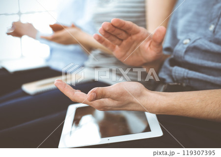 Business people clapping at meeting or conference, close-up of hands. Group of unknown businessmen and women in modern white office. Success teamwork, corporate coaching and applause concept Business people clapping at meeting or conference, close-up of hands. Group of unknown businessmen and women in modern white office. Success teamwork, corporate coaching and applause concept 119307395