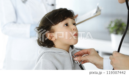 Woman-doctor examining a child patient by stethoscope. Cute arab toddler at physician appointment. Medicine concept 119307442